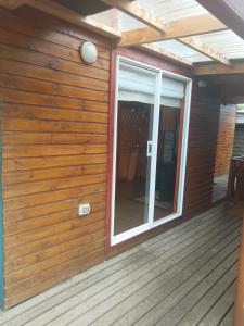 a screened in porch with a sliding glass door at Cabañas Abrumax in Hornopiren