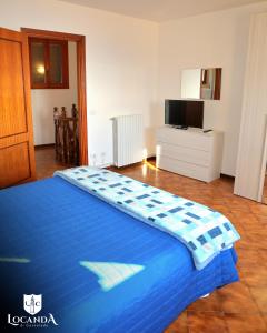 a large blue bed in a room with a television at Locanda di Cornoleda in Cinto Euganeo
