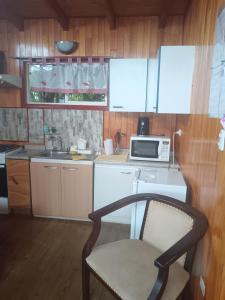 a kitchen with a microwave and a chair in it at Cabañas Abrumax in Hornopiren
