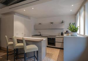 a kitchen with a counter and a table and chairs at Canonica Apartment - Eclettica Hospitality in Venice +6 photos