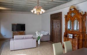 a living room with a couch and a chandelier at Canonica Apartment - Eclettica Hospitality in Venice