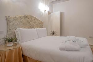 a bedroom with a white bed with a hat on it at Canonica Apartment - Eclettica Hospitality in Venice