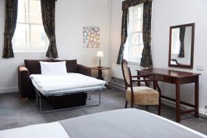 a room with a couch and a table and a desk at George Hotel by Greene King Inns in Huntingdon +45 photos