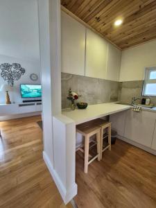 eine Küche mit weißen Schränken und einer Arbeitsplatte in der Unterkunft Vimy House in Clifden + 3 Fotos