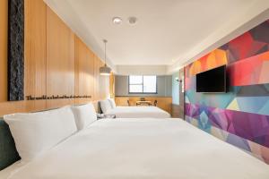 a hotel room with two beds and a tv at CHECK inn Taichung Wenxin Zhongqing in Taichung