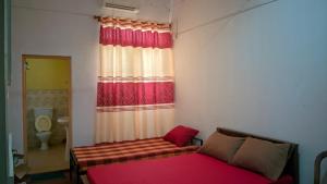 a small room with a bed and a window at RooLi Harbour Inn-Trincomalee in Trincomalee