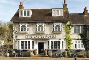 a castle hotel with tables and chairs in front of it at Castle Hotel in Eynsford