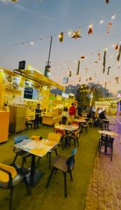 a restaurant with tables and chairs under a string of lights at The Blue Heaven in Noida