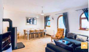 a living room with a couch and a dining room at Mountain View House - Panoramic! in Gozd Martuljek