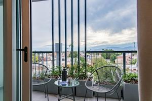 a balcony with chairs and a table with a view at Cañada Suites by FMA Coliving in Salta