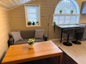 a living room with a table and a couch and a table at Sørlandets paradis in Svenevik
