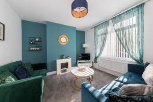 a blue living room with a couch and a table at The Relaxation Station in Bishop Auckland