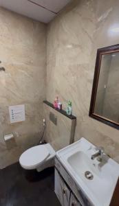 a bathroom with a white toilet and a sink at The Blue Heaven in Noida +4 photos