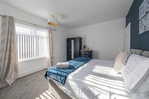 a bedroom with a large bed and a window at The Relaxation Station in Bishop Auckland
