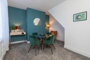 a dining room with a table and green chairs at The Relaxation Station in Bishop Auckland