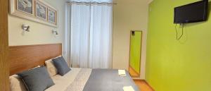 a bedroom with a bed with a television on the wall at Baixa GuestHouse in Lisbon