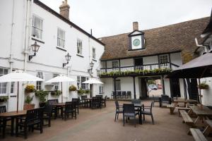 a row of tables and chairs in front of a building at George Hotel by Greene King Inns in Huntingdon