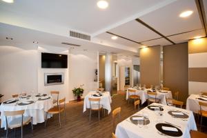 a dining room with white tables and chairs at Hotel Dei in Cascia