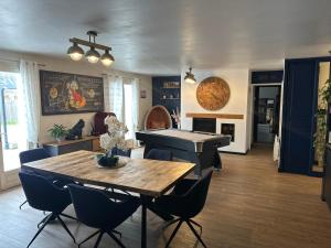 a living room with a table and a piano at La Villa cocooning in Changé