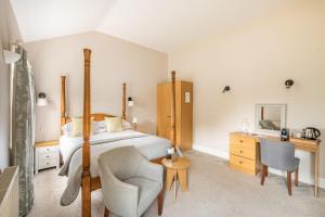 a bedroom with a bed and a desk and a chair at Bartley Lodge Hotel in Lyndhurst