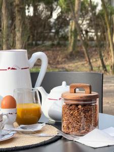 a table with a jar of granola and a cup of orange juice at Maison d'Hôtes HAITZ TEYA - La Chênaie in Ascain