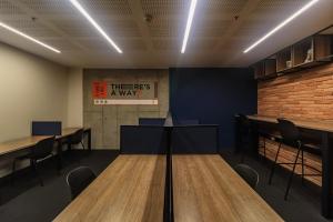 a conference room with tables and chairs and a brick wall at Happa Hub Hotel in Bogotá