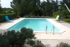 a large swimming pool with chairs at La bergerie in Chaillevette