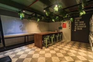 a restaurant with a bar with stools and lights at Happa Hub Hotel in Bogotá