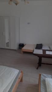a room with three beds and a table in it at Pokoje do wynajęcia w domku in Ryczówek