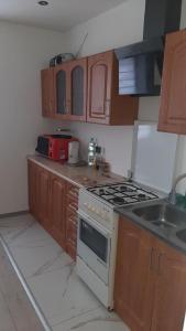 a kitchen with a stove top oven next to a sink at Pokoje do wynajęcia w domku in Ryczówek