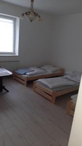 two beds in a room with a window at Pokoje do wynajęcia w domku in Ryczówek