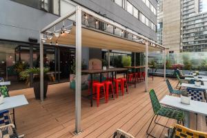 a restaurant with tables and chairs on a deck at Happa Hub Hotel in Bogotá