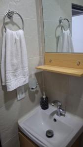 a bathroom with a sink and a mirror and towels at Apartamento en Roldanillo in Roldanillo