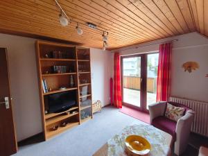 a living room with a tv and a couch and a table at Gästehaus Heuchert in Meersburg
