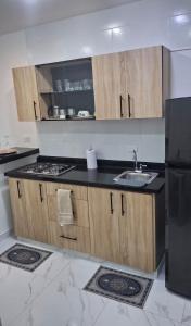 a kitchen with a sink and a black refrigerator at Apartamento en Roldanillo in Roldanillo