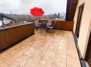 a patio with a table and chairs and an umbrella at Gästehaus Heuchert in Meersburg
