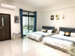 a bedroom with two beds and a large window at 芯之所嚮 in Hualien City