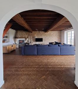 a large living room with a blue couch in the middle at Les Côtes - Charming holiday home with heated swimming pool in Palluaud