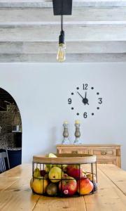 a clock and a basket of fruit on a table at Les Côtes - Charming holiday home with heated swimming pool in Palluaud
