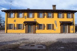 a yellow house with windows on the side of it at Gaspari Farm Relais in Volta Mantovana
