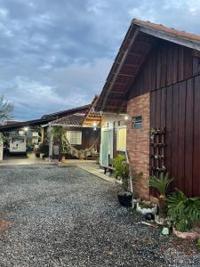 a house with a gravel driveway in front of it at Pousada 03 do vô Bi in São Francisco do Sul