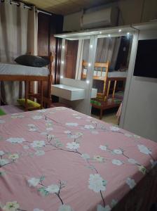 a bedroom with a pink bed with flowers on it at Pousada 03 do vô Bi in São Francisco do Sul