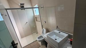 a bathroom with a sink and a toilet and a shower at Chalés Brisas do Lago Capitólio in Capitólio