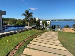 a walkway in front of a house next to the water at Chalés Brisas do Lago Capitólio in Capitólio