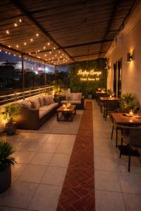 an outdoor patio with couches and tables and lights at Hotel Aarav 94 in Indore