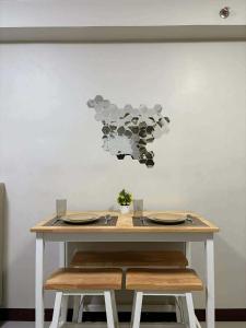a table with two chairs and a table with plates at Studio Stay at Saekyung Condominium in Lapu Lapu City