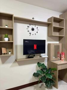 a room with a tv and a clock on the wall at Studio Stay at Saekyung Condominium in Lapu Lapu City