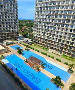 an aerial view of two pools in front of a large building at Studio Stay at Saekyung Condominium in Lapu Lapu City