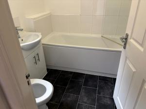 a bathroom with a white tub and a toilet and a sink at Doncaster City Centre Immaculate 1 Bedroom flat in Doncaster