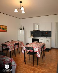 a kitchen with two tables and chairs in a room at Locanda di Cornoleda in Cinto Euganeo